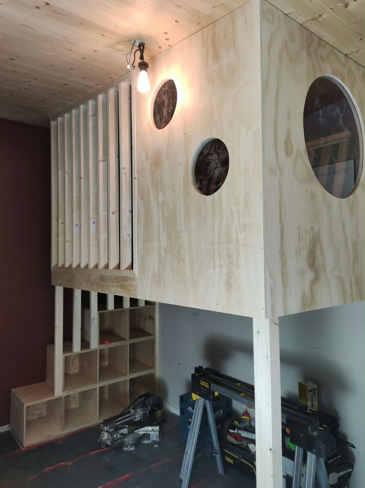 Houten maatwerk hoogslaper met ronde openingen en opbergvakken