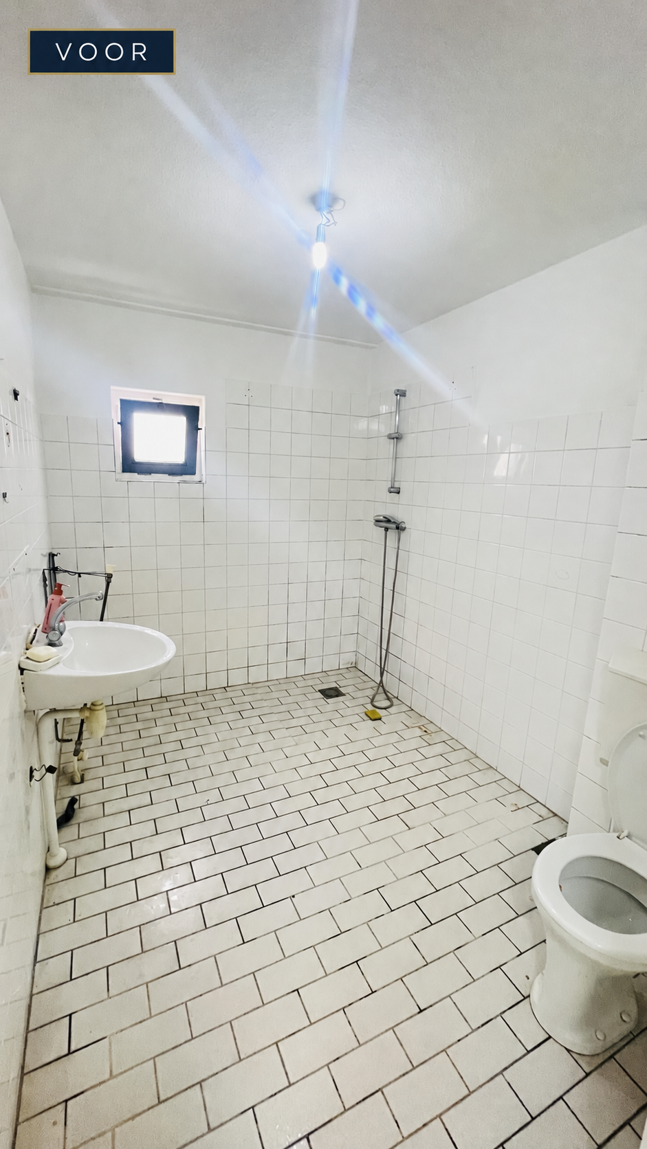 Voor de badkamerrenovatie: bestaande badkamer met witte wand- en vloertegels