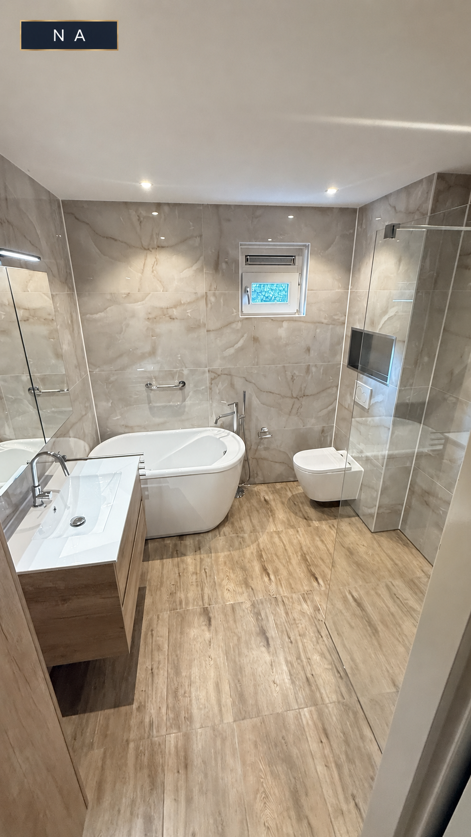 Na de badkamerrenovatie: badkamer met hoekbad, inloopdouche en houtlook vloer