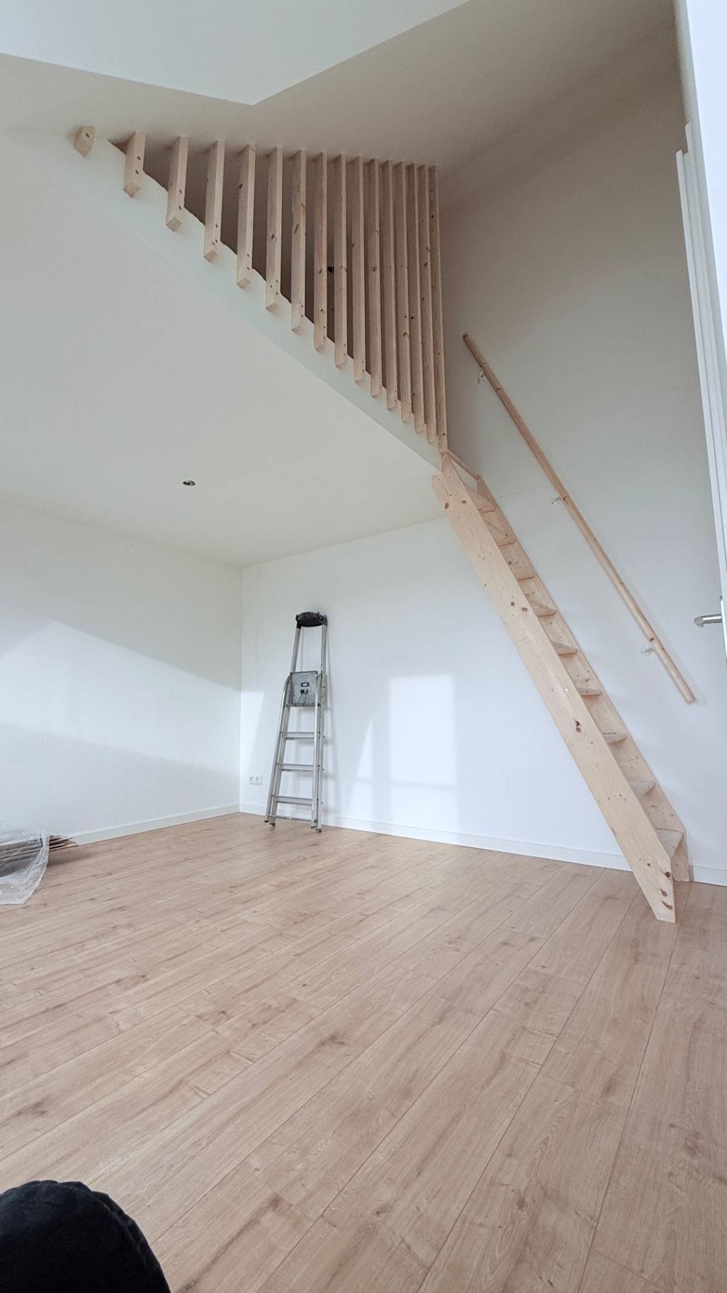Houten trap met maatwerk balustrade in een lichte ruimte